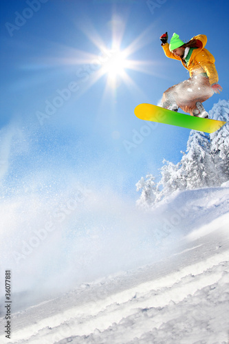 Photo: Snowboarder jumping against blue sky Snowboarder jumping against blue sky