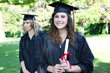 Foto: Pretty young woman at graduation holding diploma Pretty young woman at graduation holding diploma