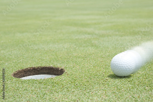 Photo: golf ball on lip of cup golf ball on lip of cup
