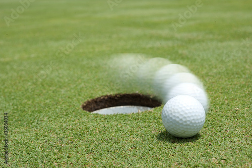 Photo: golf ball on lip of cup golf ball on lip of cup