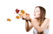 woman on the autumn leaves blowing in her hands.