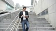 Man using electronic tablet while walking downstairs Man using electronic tablet while walking downstairs