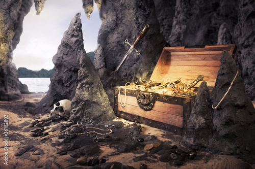 Photo: open treasure chest with bright gold in a cave open treasure chest with bright gold in a cave