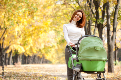 Photo: Happy young mother with baby in buggy Happy young mother with baby in buggy