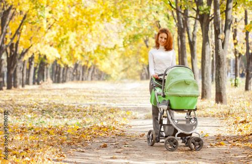 Photo: Happy young mother with baby in buggy Happy young mother with baby in buggy
