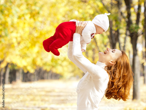 Photo: Young mother playing with daughter in autumn park Young mother playing with daughter in autumn park