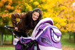 young mother with baby in stroller walks in park