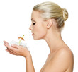 Foto: Beautiful young woman holding a white lily at face Beautiful young woman holding a white lily at face