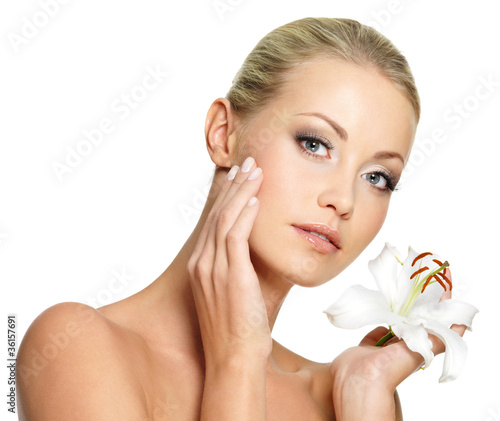 Photo: Beauty face of the young beautiful woman with flower Beauty face of the young beautiful woman with flower