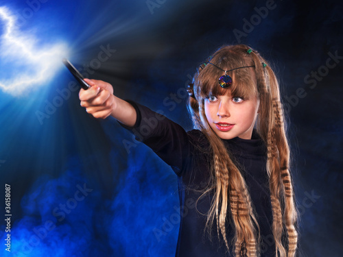 Photo: Girl in witch's hat with magic wand. Girl in witch's hat with magic wand.