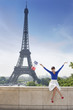 Photo: Woman holding a French flag sitting on a stone wall with the Eiffel Tower in the background, Paris, Ile-de-France, France Woman holding a French flag sitting on a stone wall with the Eiffel Tower in the background, Paris, Ile-de-France, France