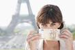Photo: Woman showing 50 Euro banknote with the Eiffel Tower in the background, Paris, Ile-de-France, France Woman showing 50 Euro banknote with the Eiffel Tower in the background, Paris, Ile-de-France, France