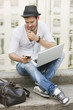 Photo: Man sitting on the ledge of a canal and talking on a mobile phone, Paris, Ile-de-France, France Man sitting on the ledge of a canal and talking on a mobile phone, Paris, Ile-de-France, France