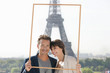 Foto: Portrait of a couple framing their dream vacation with Eiffel Tower, Paris, Ile-de-France, France Portrait of a couple framing their dream vacation with Eiffel Tower, Paris, Ile-de-France, France