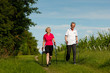Glückliches älteres Paar beim Nordic Walking im Sommer