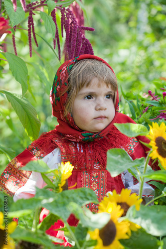 Photo: little girl in Russian national dress among sunflowers little girl in Russian national dress among sunflowers