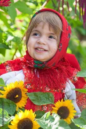 Photo: little girl in Russian national dress among sunflowers little girl in Russian national dress among sunflowers