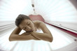 Beautiful young woman tanning in solarium