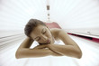 Beautiful young woman tanning in solarium