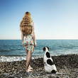 Beautiful woman with a dog on the beach