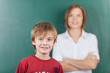portrait schulkind und lehrerin vor der tafel