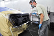 Worker painting a car. Worker painting a car.