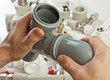 plumbing fittings in his hand