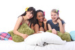 Pyjama party fun for teenage girls in bed at home