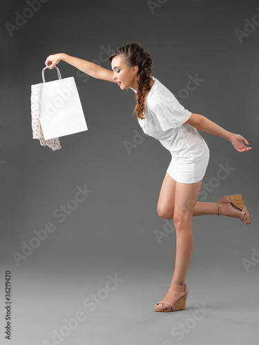 Photo: fashionable young woman holding shoppping bag, tumbling fashionable young woman holding shoppping bag, tumbling