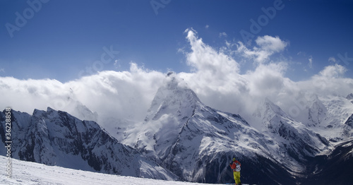 Photo: Panorama Mountains. Ski slope with skier. Panorama Mountains. Ski slope with skier.