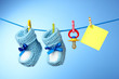 baby booties, nipple and yellow card on a blue background baby booties, nipple and yellow card on a blue background