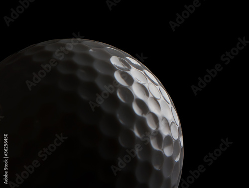 Photo: Close up of a golf ball on black Close up of a golf ball on black