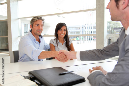 Photo: Man giving handshake to real-estate-agent Man giving handshake to real-estate-agent