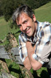 Portrait of handsome breeder leaning on fence