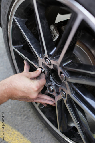 Photo: Man installs spare wheel Man installs spare wheel