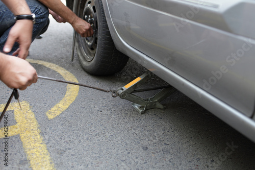 Photo: Man used a jack to lift his car Man used a jack to lift his car