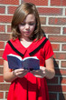 Pretty Young Girl in red dress holding Bible