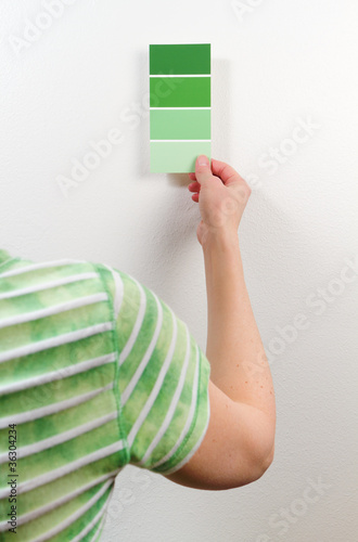 Photo: Woman choosing among green paint swatches Woman choosing among green paint swatches