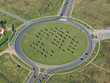 Aerial photo of a roundabout with grass and trees in the middle