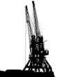 Silhouettes of two port cranes