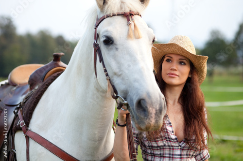 Foto: Beautiful cowgirl taking her horse for a ride Beautiful cowgirl taking her horse for a ride