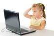 Little girl with a surprised face is on the computer
