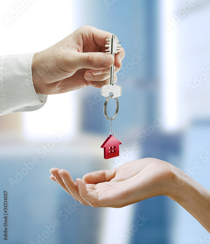 Photo: Man is handing a house key to a woman Man is handing a house key to a woman