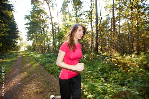 Photo: Junge Frau genießt Joggen im Wald Junge Frau genießt Joggen im Wald