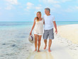 Beautiful mature couple walking along the beach