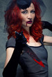 Foto: Redhead woman with blood on her lips and bloody knife in hand Redhead woman with blood on her lips and bloody knife in hand
