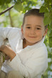 little boy smiling while climbing tree