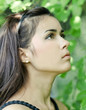Portrait of beautiful cute young girl yearning in leafage outdoo