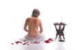 spa, naked woman sitting in back with rose petals