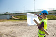 lady engineer looking at blueprints in construction site
